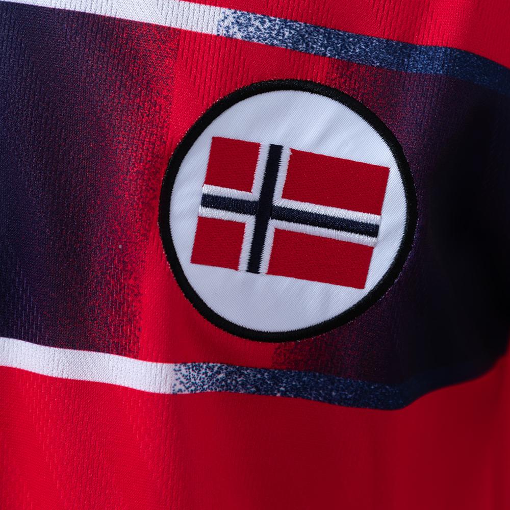 Detalj av det norske landslags-emblemet integrert i kors-designet på retro-drakten fra 1997