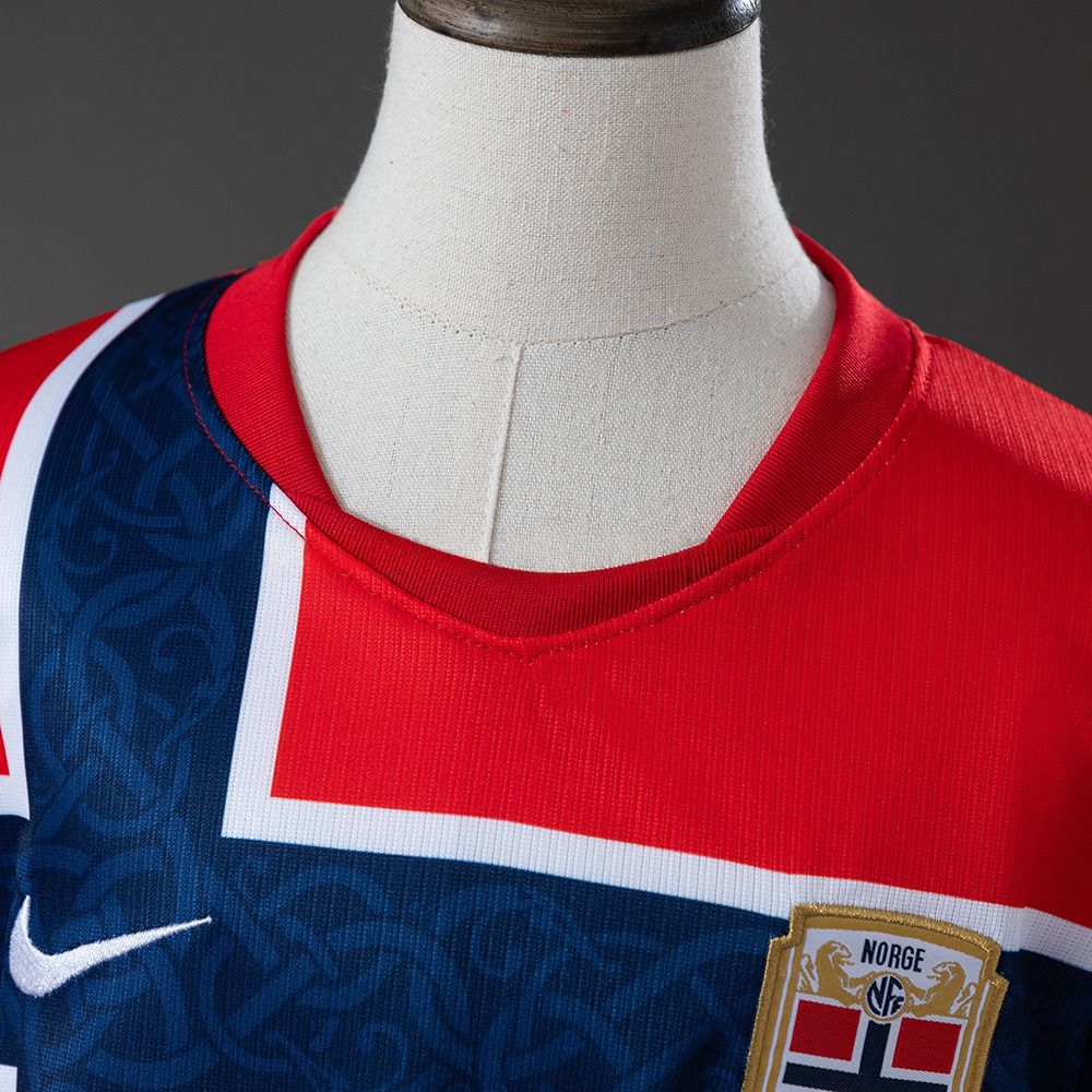 Nærbilde av kragen og det grafiske mønsteret på Norges VM 2026-drakt for barn