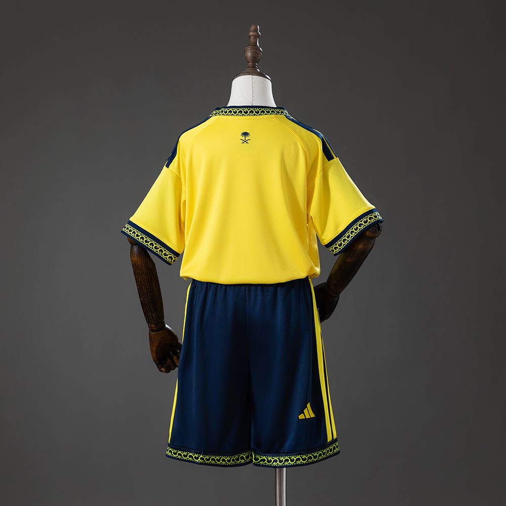 Baksiden av Al-Nassr draktsett 26/27 for barn med gul overdel og marineblå shorts