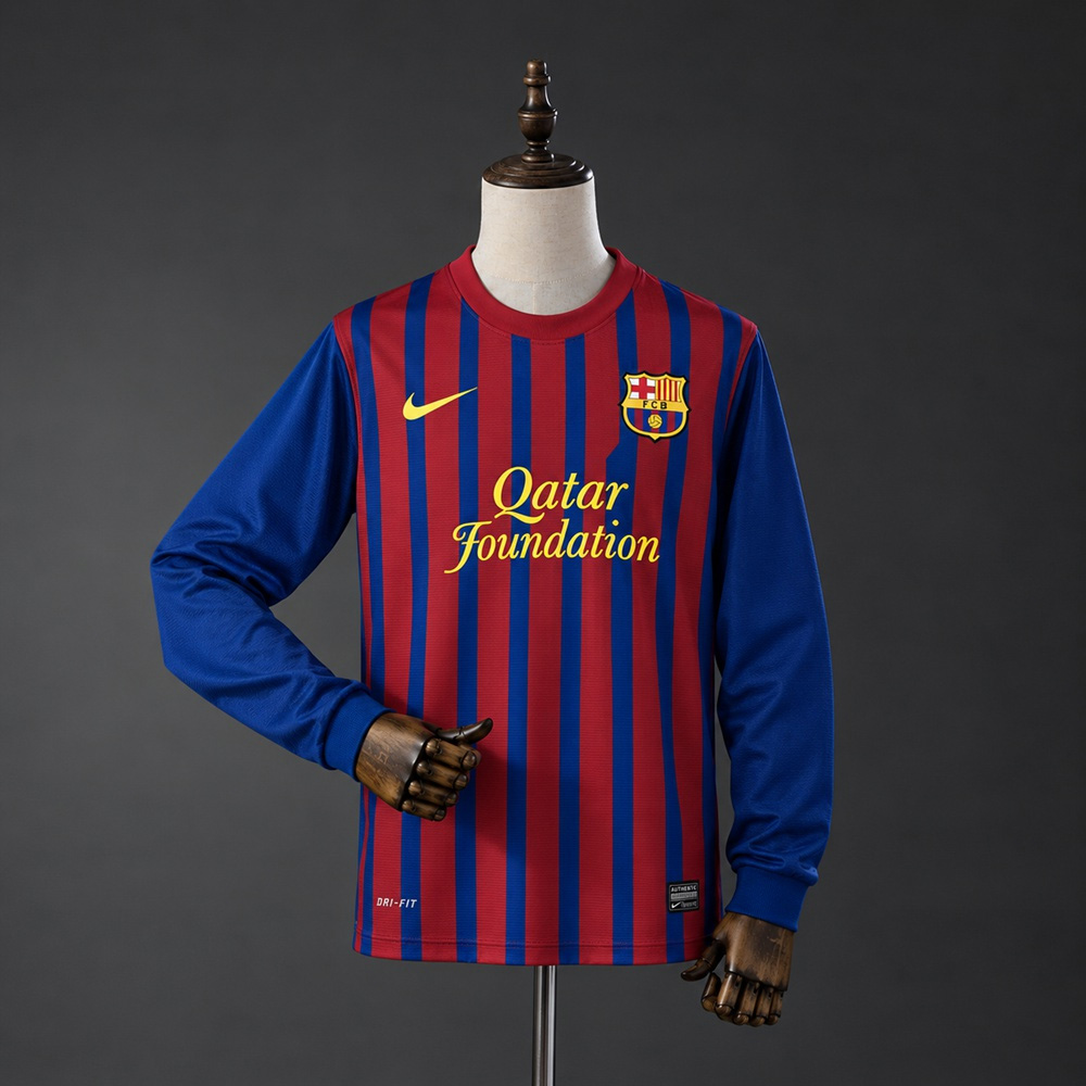 Barcelona hjemmedrakt fra 2011/12 i retrostil, vist på dukke med røde og blå striper og ensfargede blå lange ermer
