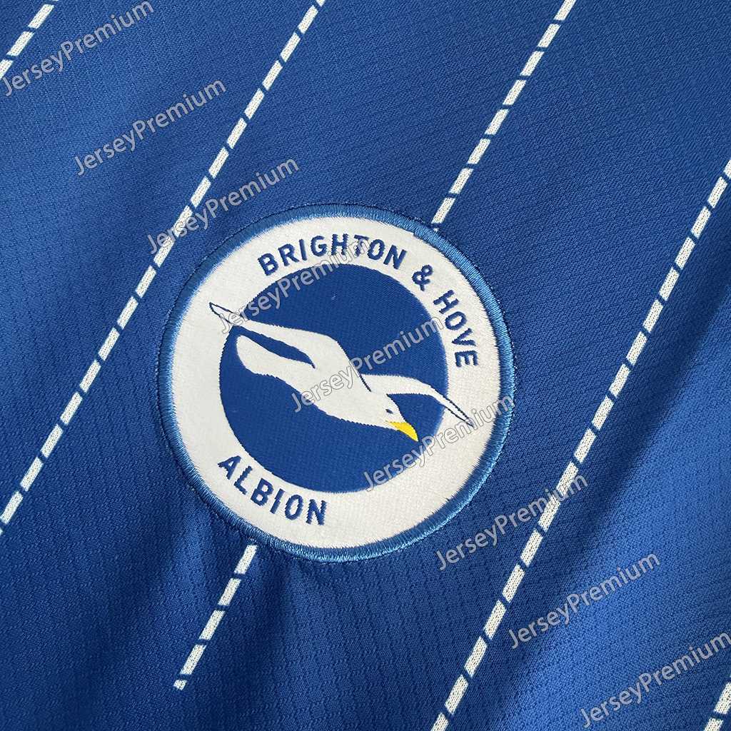 Nærbilde av Brighton-klubbmerket og hvite nålestriper på 26/27 hjemmedrakten
