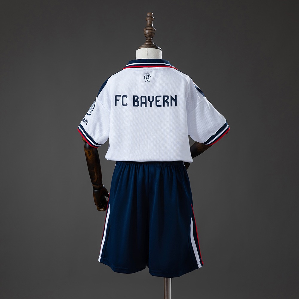 Baksiden av Bayern Munich sitt hvite 26/27-draktsett for barn med marineblå shorts