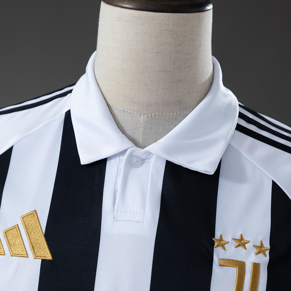 Knappestolpe under den hvite polokragen og gullfarget Juventus-merke med tre stjerner på brystet