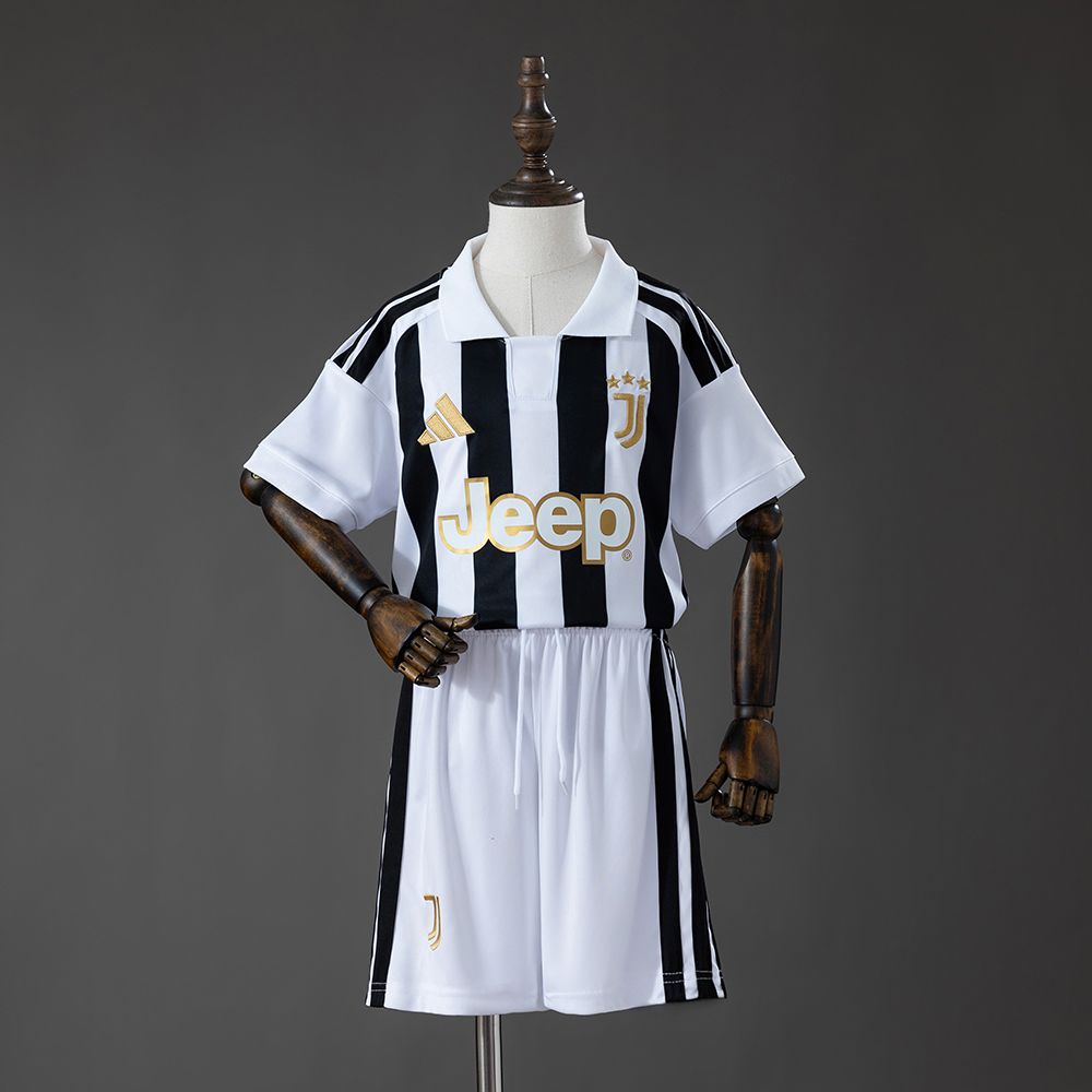 Juventus barnesett på dukke med svart-hvit stripete drakt, hvit polokrage, gulldetaljer og hvite shorts