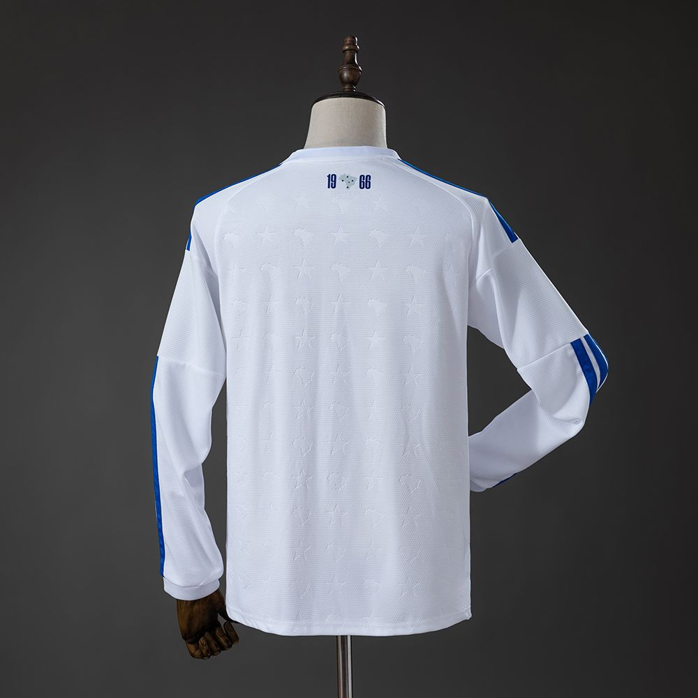 Fem blå stjerner på brystet og et svakt stjernemønster i det hvite stoffet på Cruzeiro-drakten