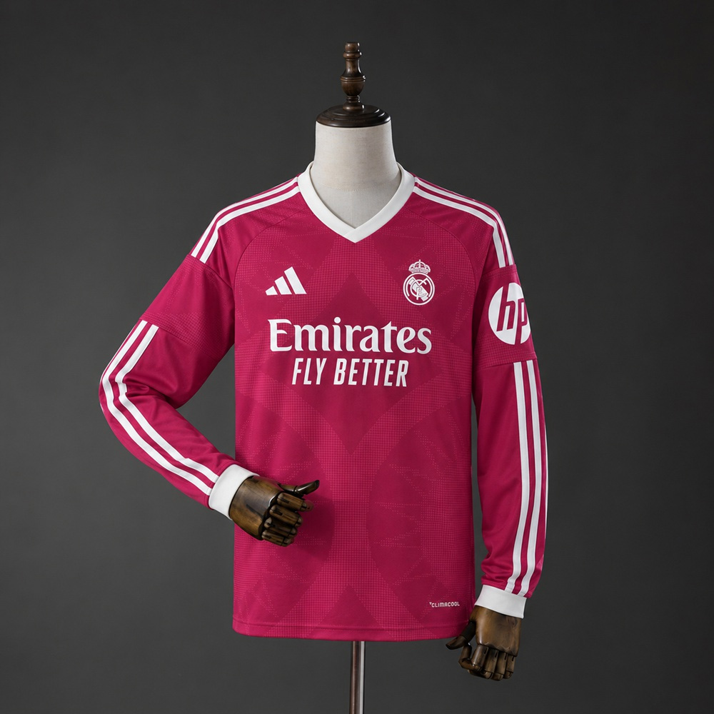 ALT： Real Madrid tredjedrakt 26/27 vist på utstillingsdukke, med rødrosa mønster, lange ermer og lys V-hals