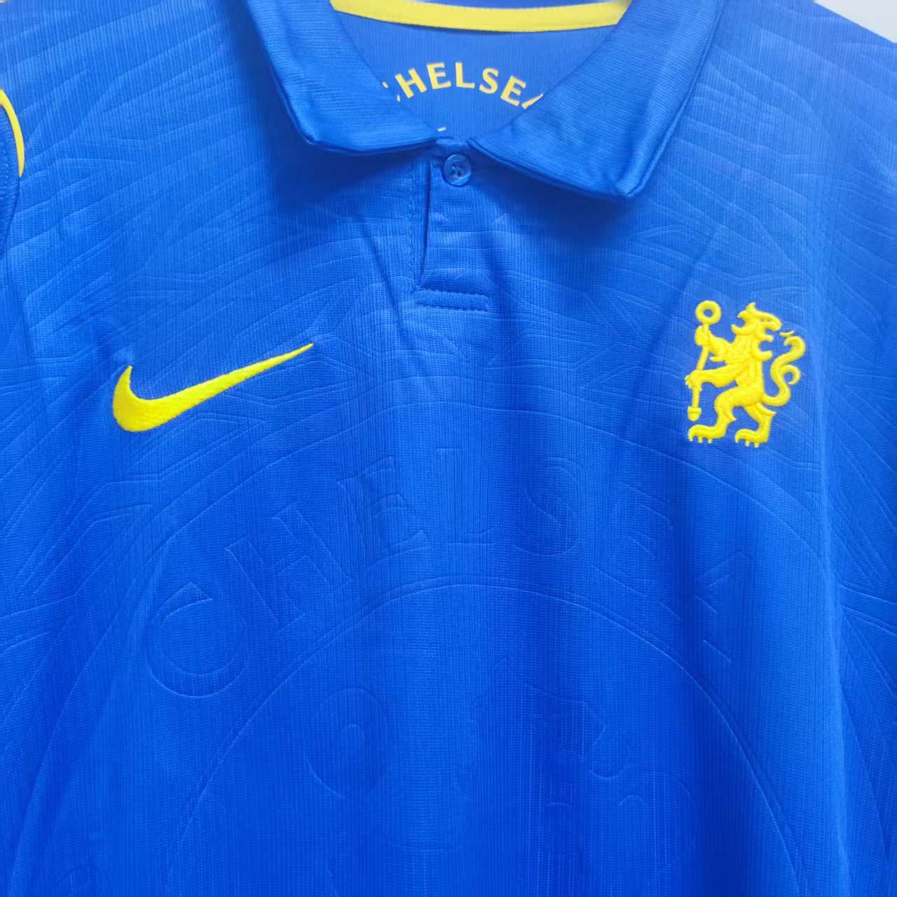 Detalj av krage, gul løve og diskret klubbmotiv på Chelsea hjemmedrakt 26/27