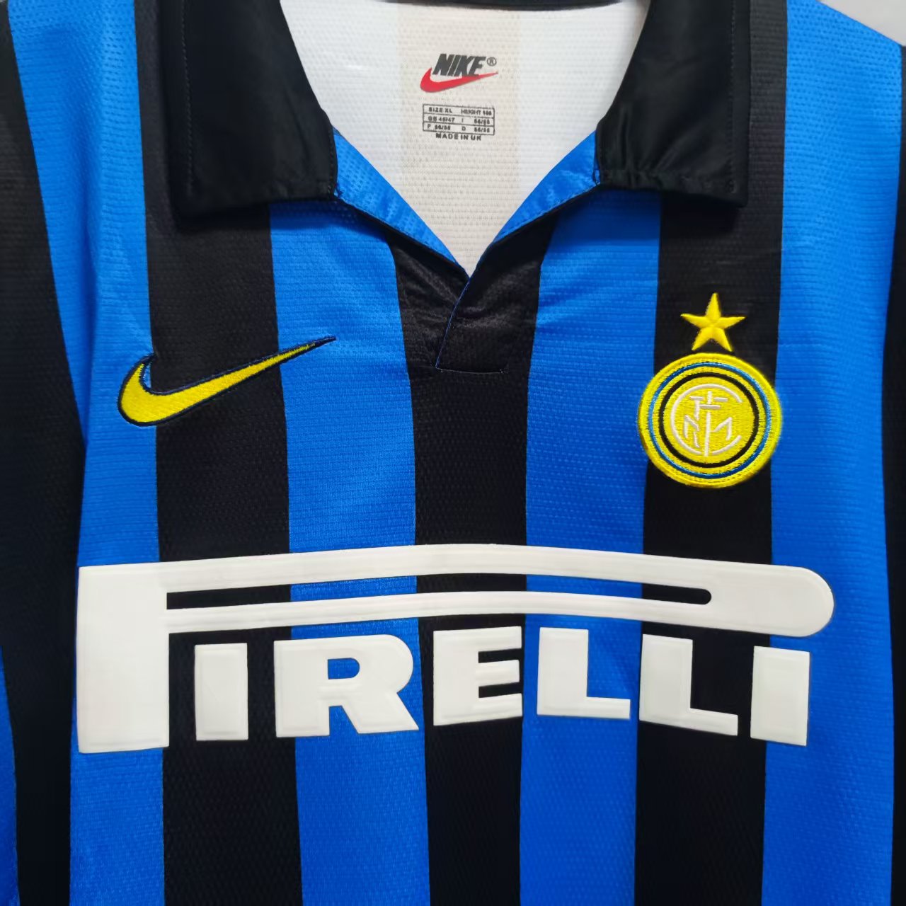 Svart polokrage og gult klubbmerke på Inter Milan 1998/99 hjemmedrakt