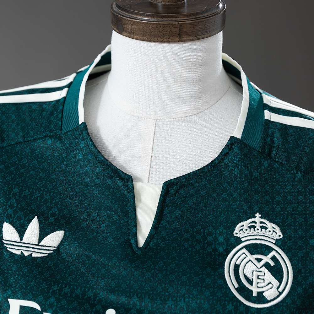 Hals og klubbemblem på mørkegrønn Real Madrid damefotballdrakt
