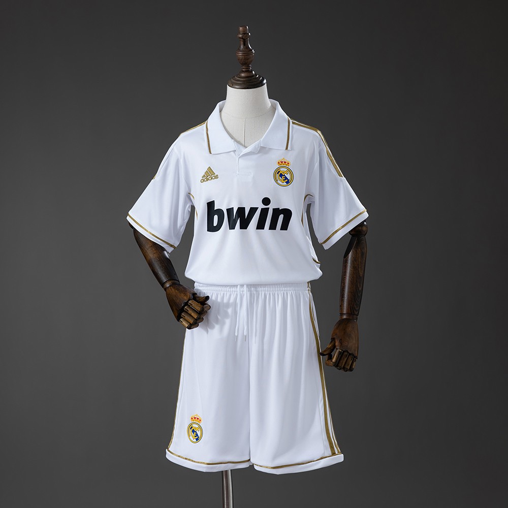 Hvit Real Madrid hjemmedrakt barn 2011/12 med gulldetaljer og shorts sett forfra