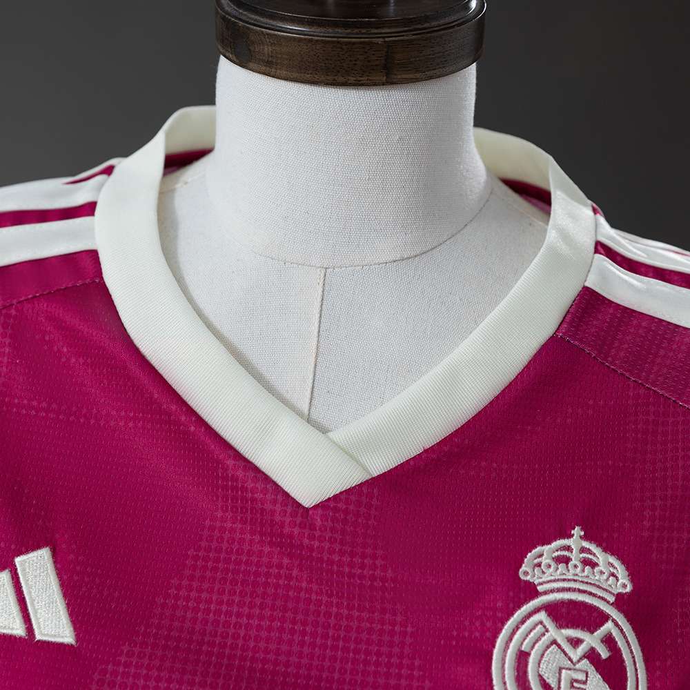 V-hals og klubbemblem på rosa Real Madrid tredjedrakt for dame