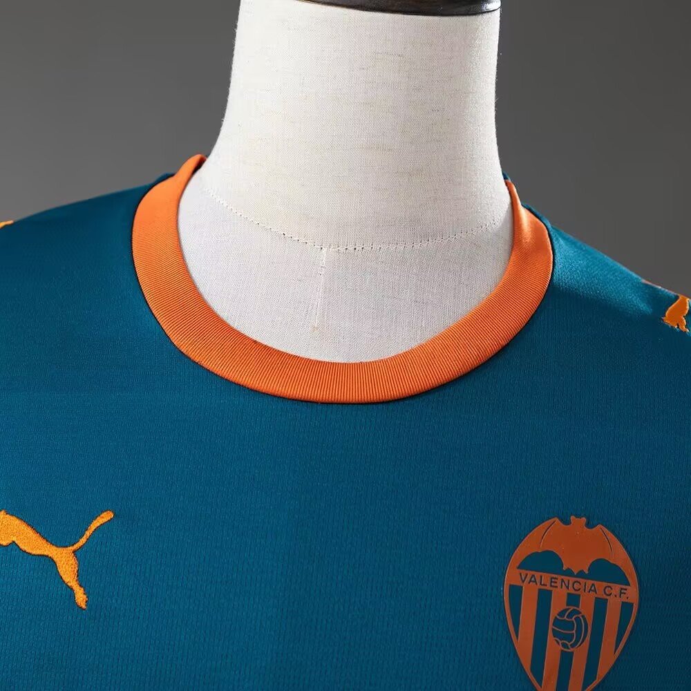 Oransje hals og klubbmerke på Valencia 2026/27 bortedrakt